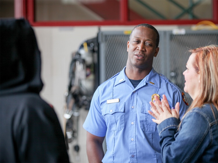 Firefighter talking to two visitors.